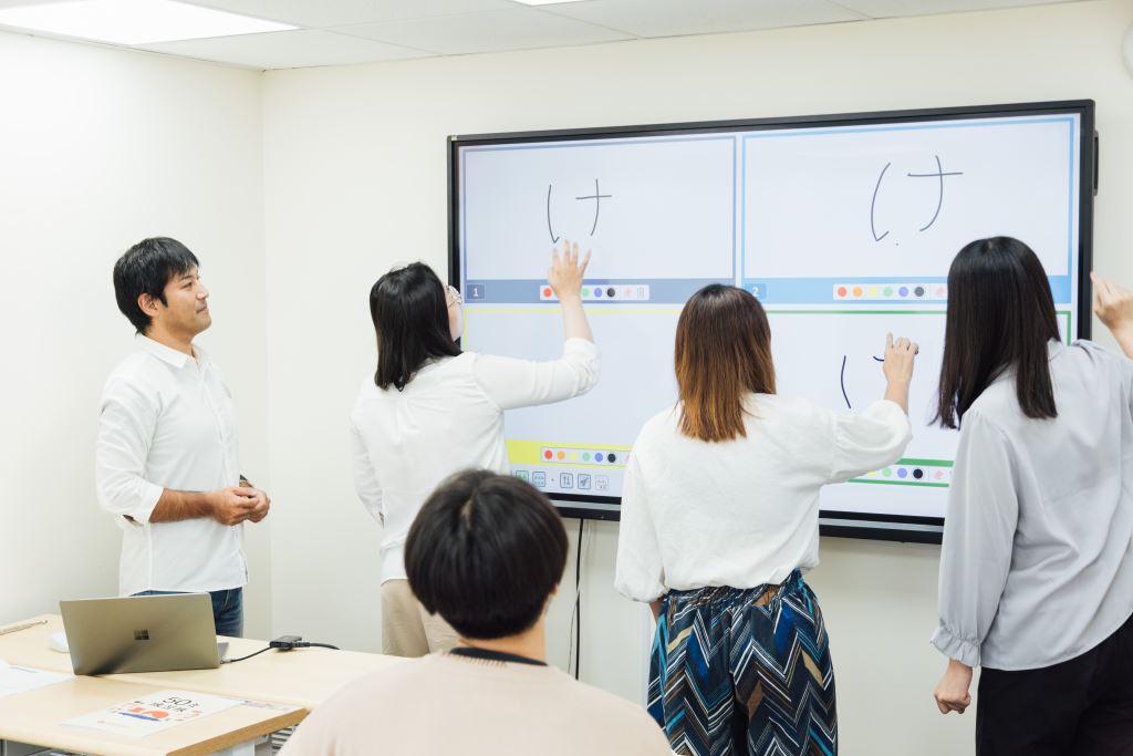 學生跟著日籍老師在電子白板前練習日文